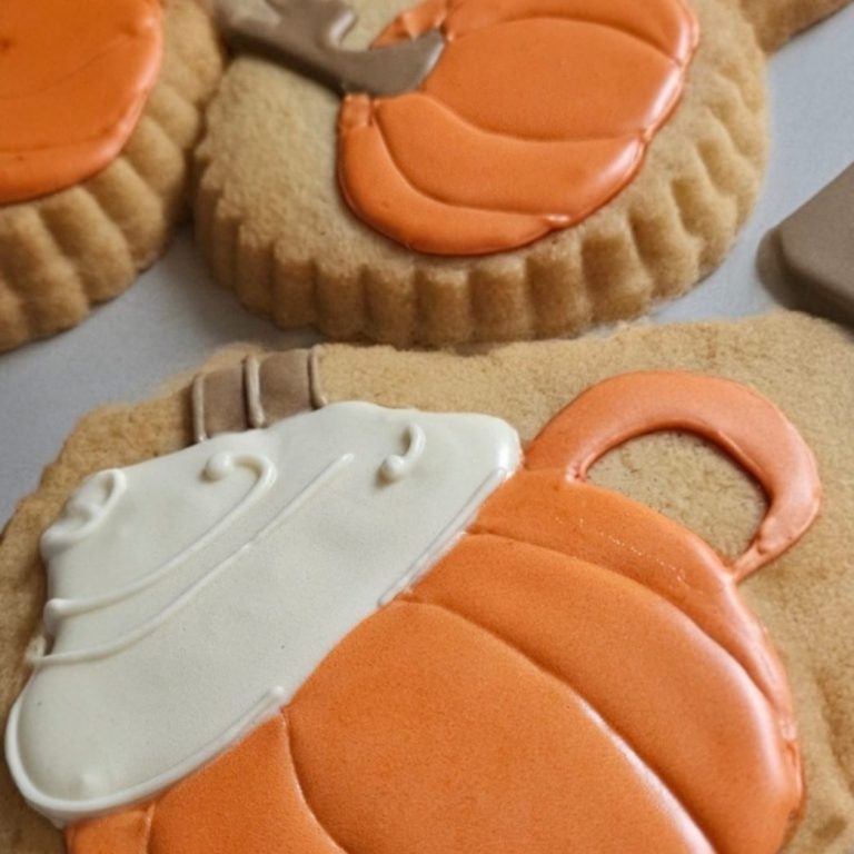 Bikini rouge biscuits décorés Un biscuit en forme de maillot de bain rouge à pois blancs sur fond de plage.