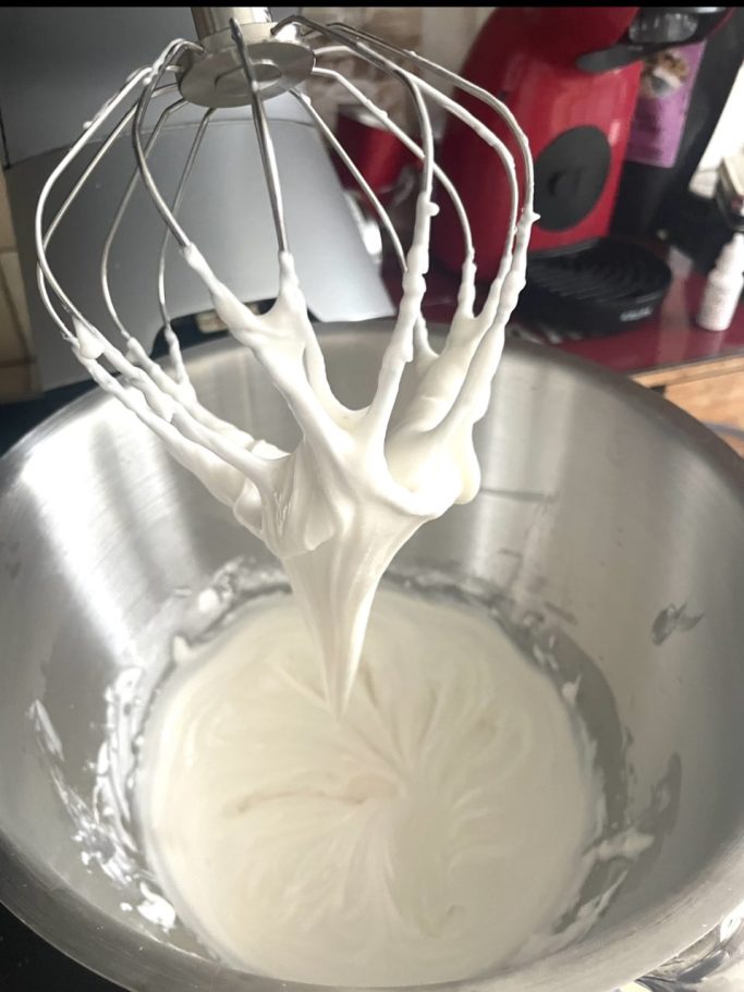 biscuits décorés Mélangeur avec des fouets, crémeux blanc dans un bol en inox.