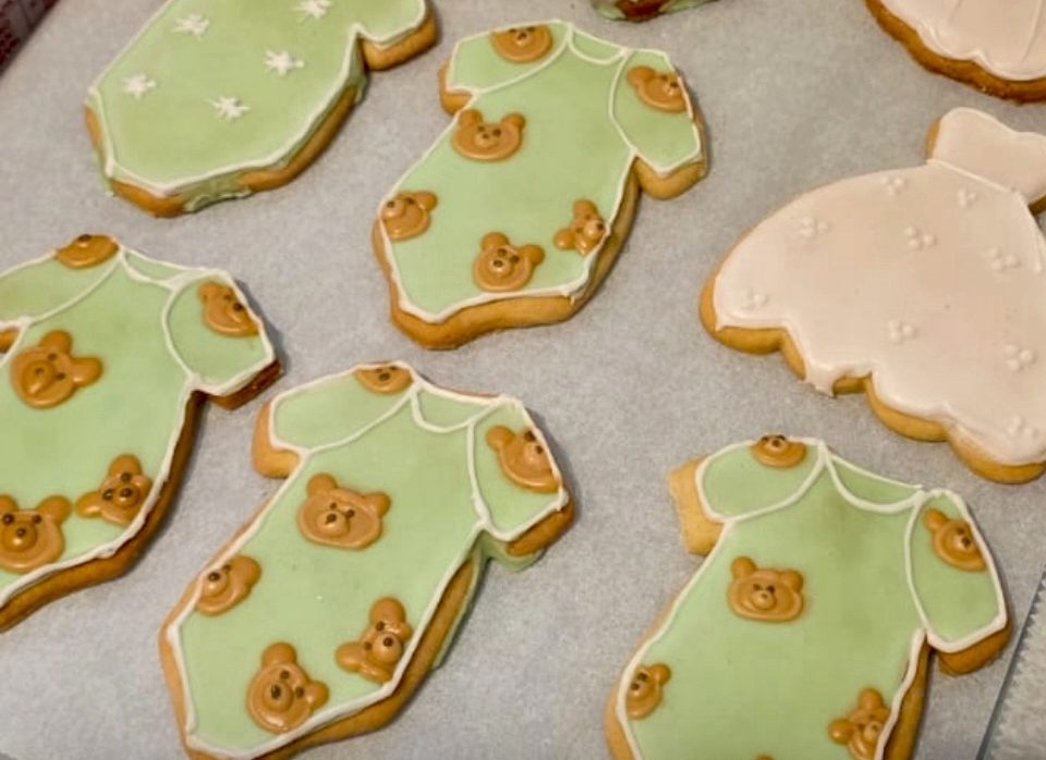 Biscuits en forme de robe rouge avec des motifs floraux et une bordure décorative.
